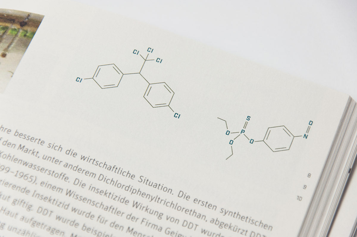 Das aufgeschlagene Buch "Pillen und Pipetten" zeigt die grafische Darstellung einer chemischen Verbindung