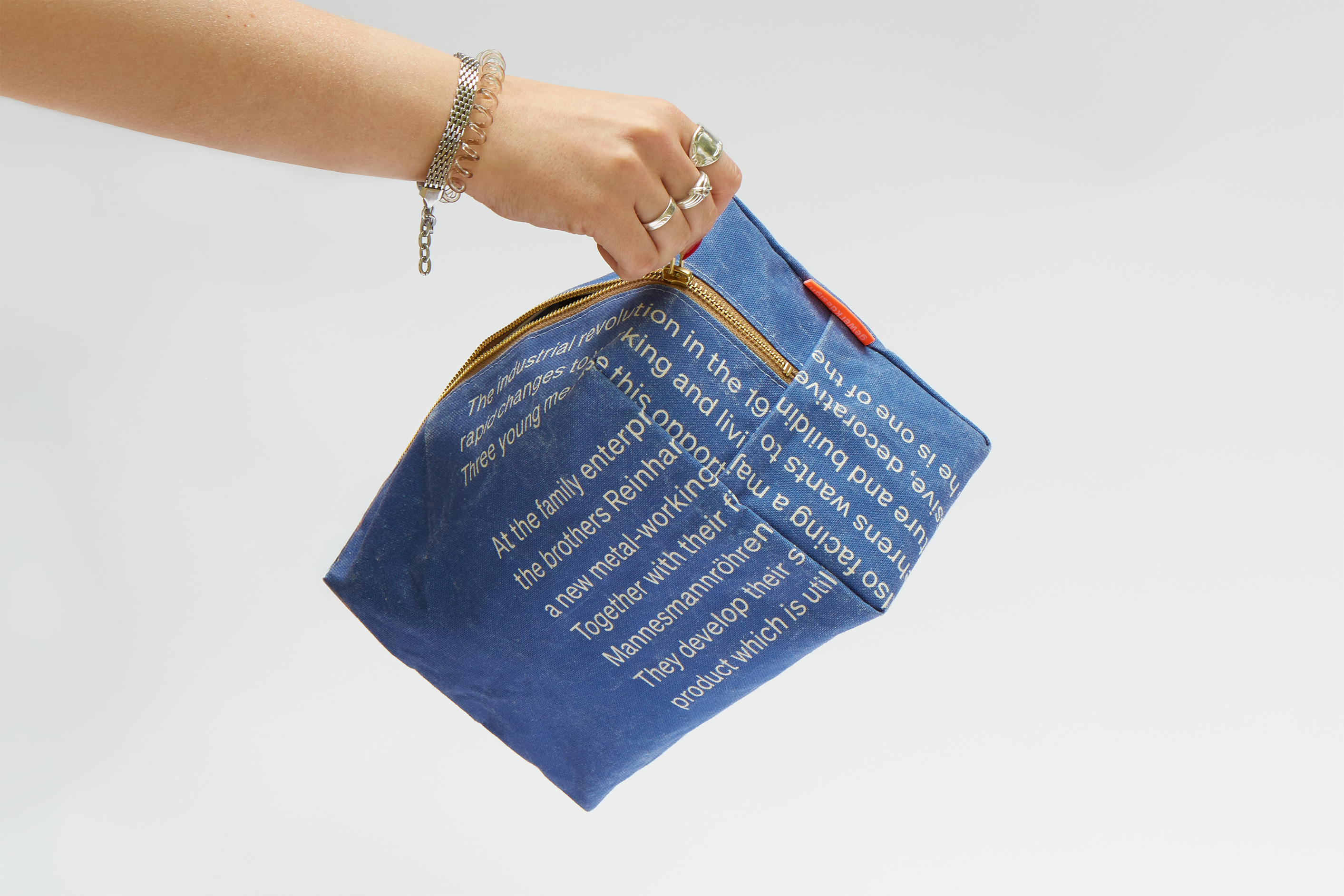 Eine Hand zieht den Reißverschluss der Kulturtasche auf