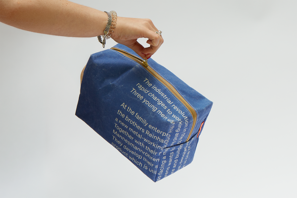 Eine Hand zieht den Reißverschluss der Kulturtasche auf