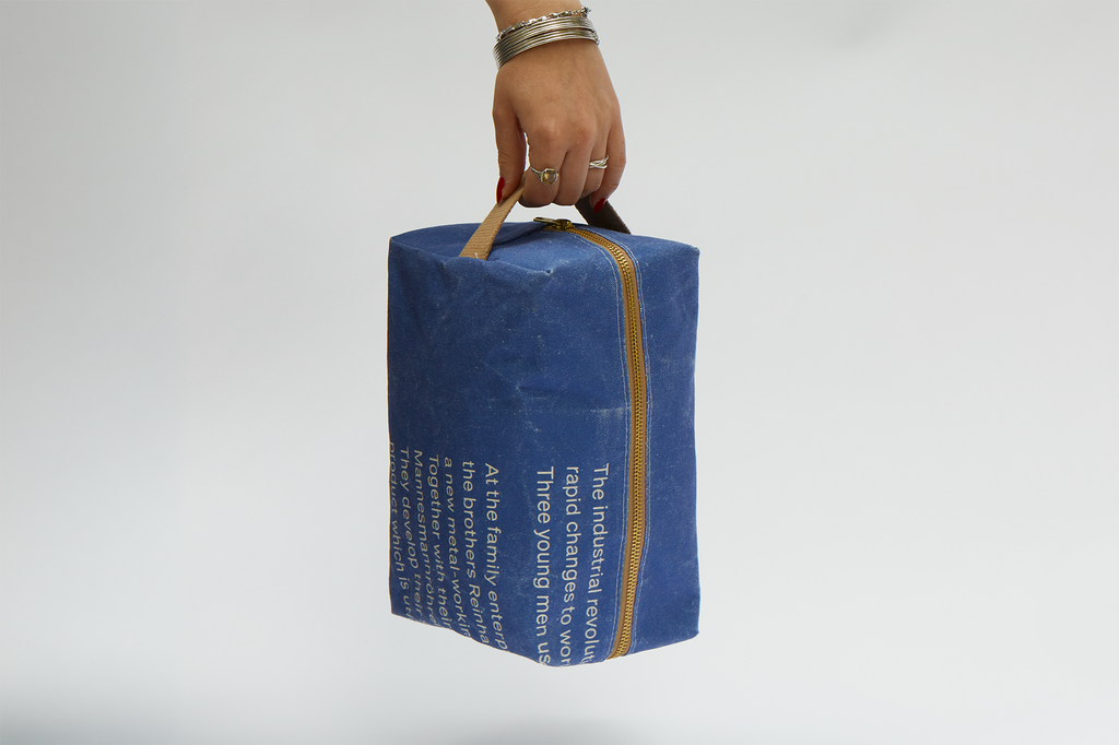 Die Kulturtasche wird von einer Hand am Tragegriff gehalten