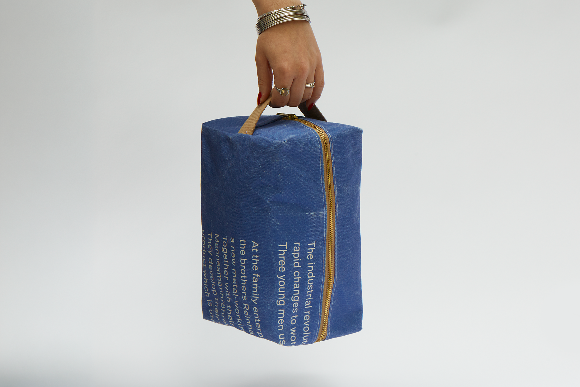 Die Kulturtasche wird von einer Hand am Tragegriff gehalten