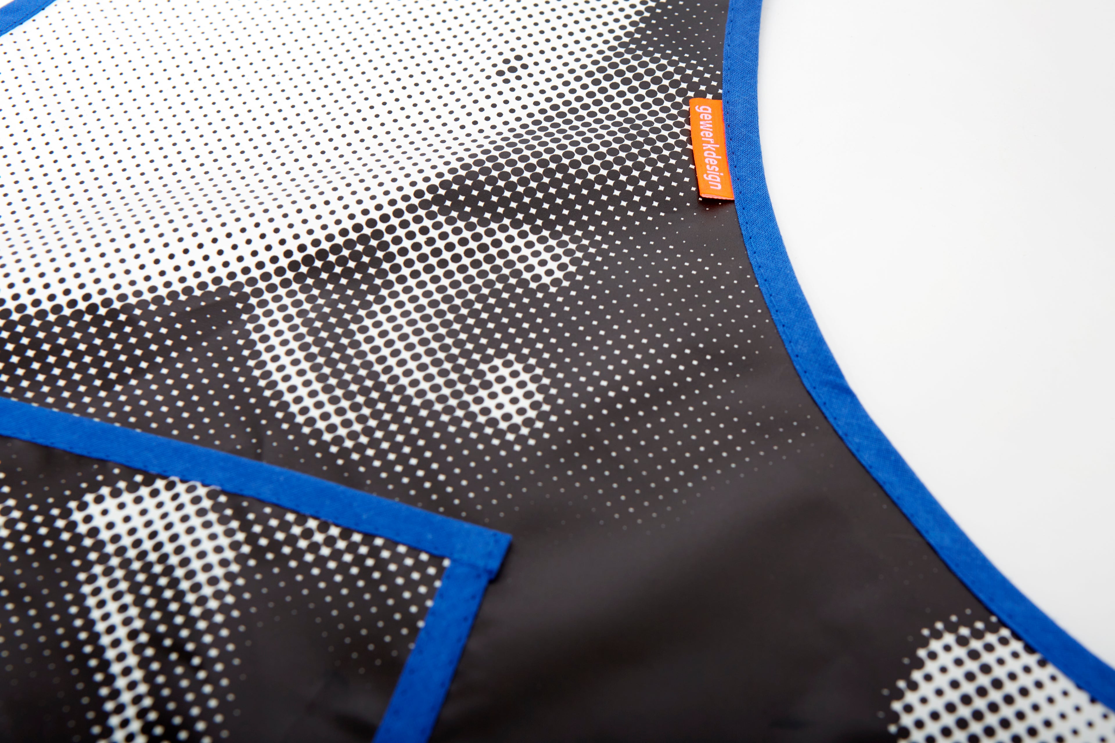 Ein Close-up der Schürze zeigt das Punktmuster und das gewerkdesign-Label